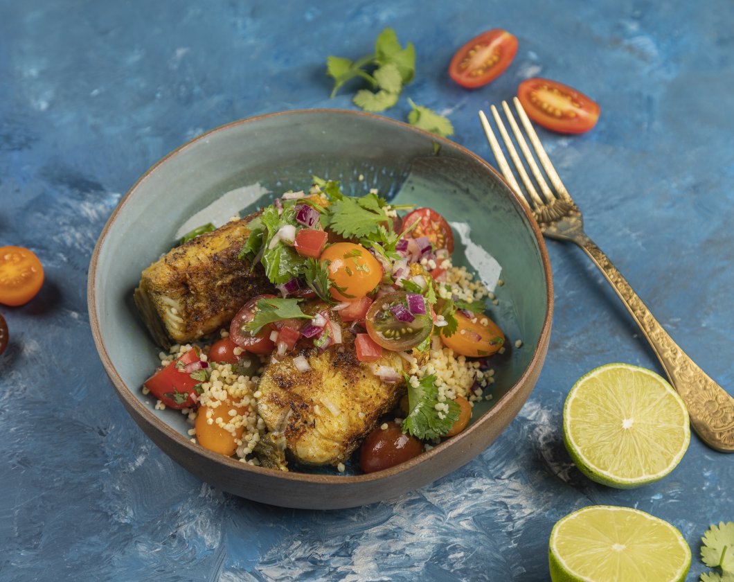 Grilled bellied cod curry on couscous with tomatoes and coriander