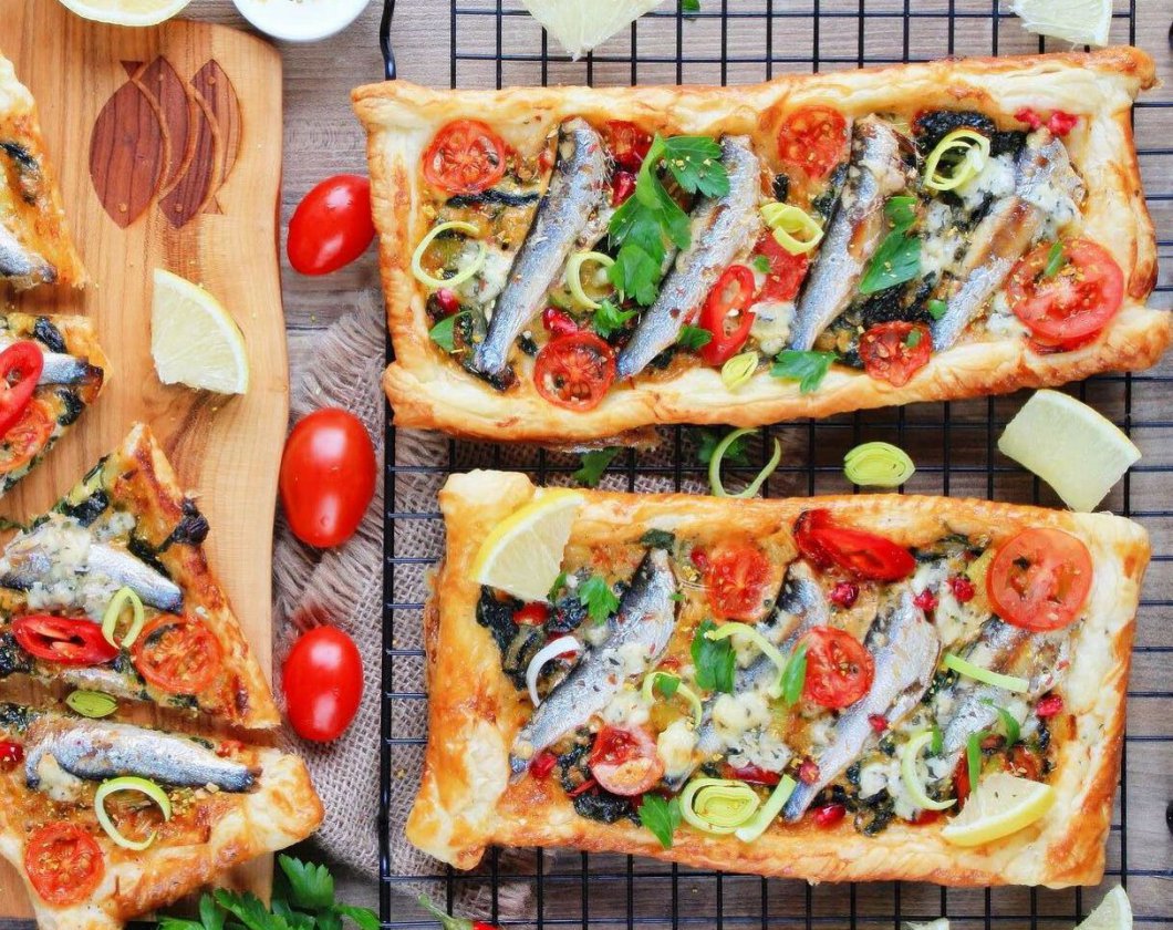 Mini puff pastry tarts with leek, spinach, sprats and tomatoes