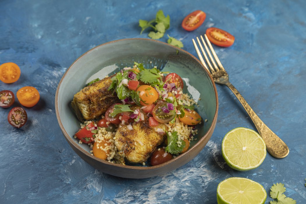 Grilled bellied cod curry on couscous with tomatoes and coriander